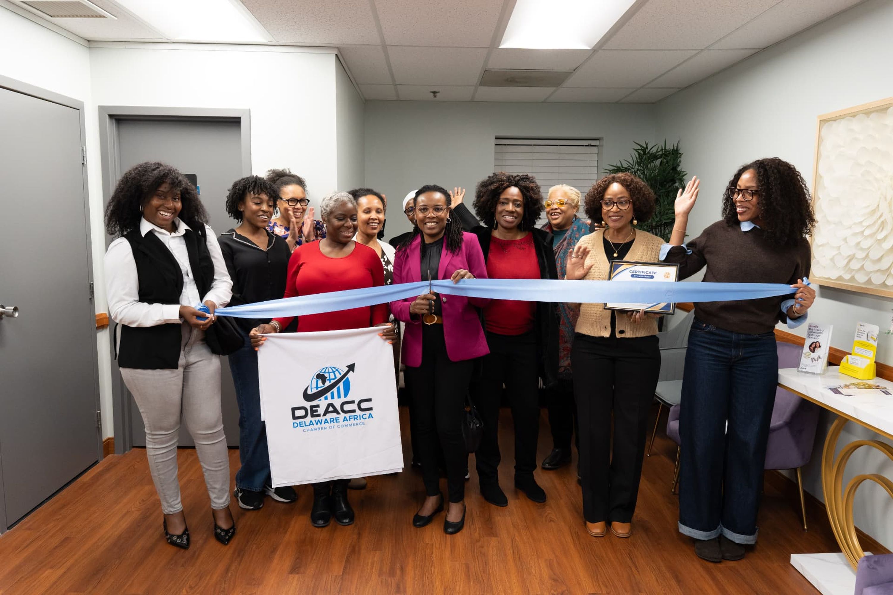 Group holding a ribbon and certificate at a ribbon cutting