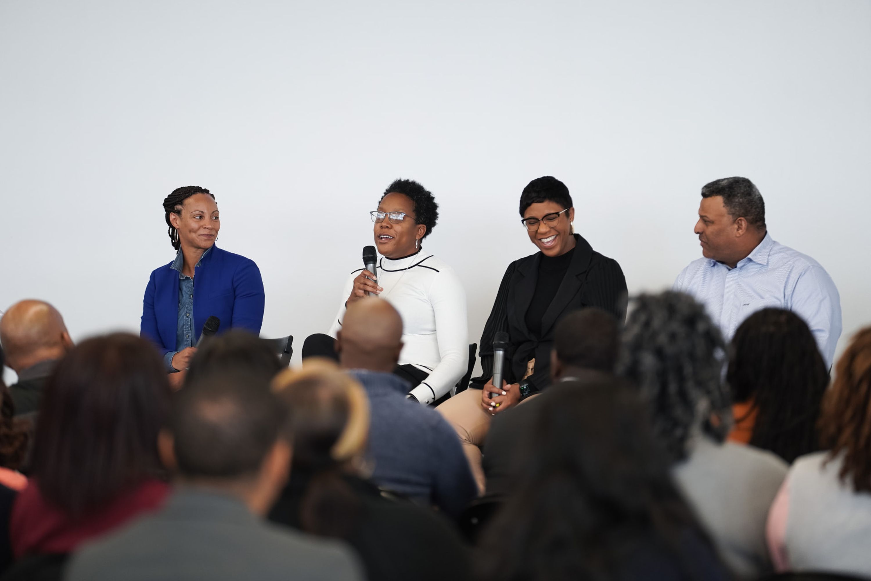 Four panelists with audience members in the foreground