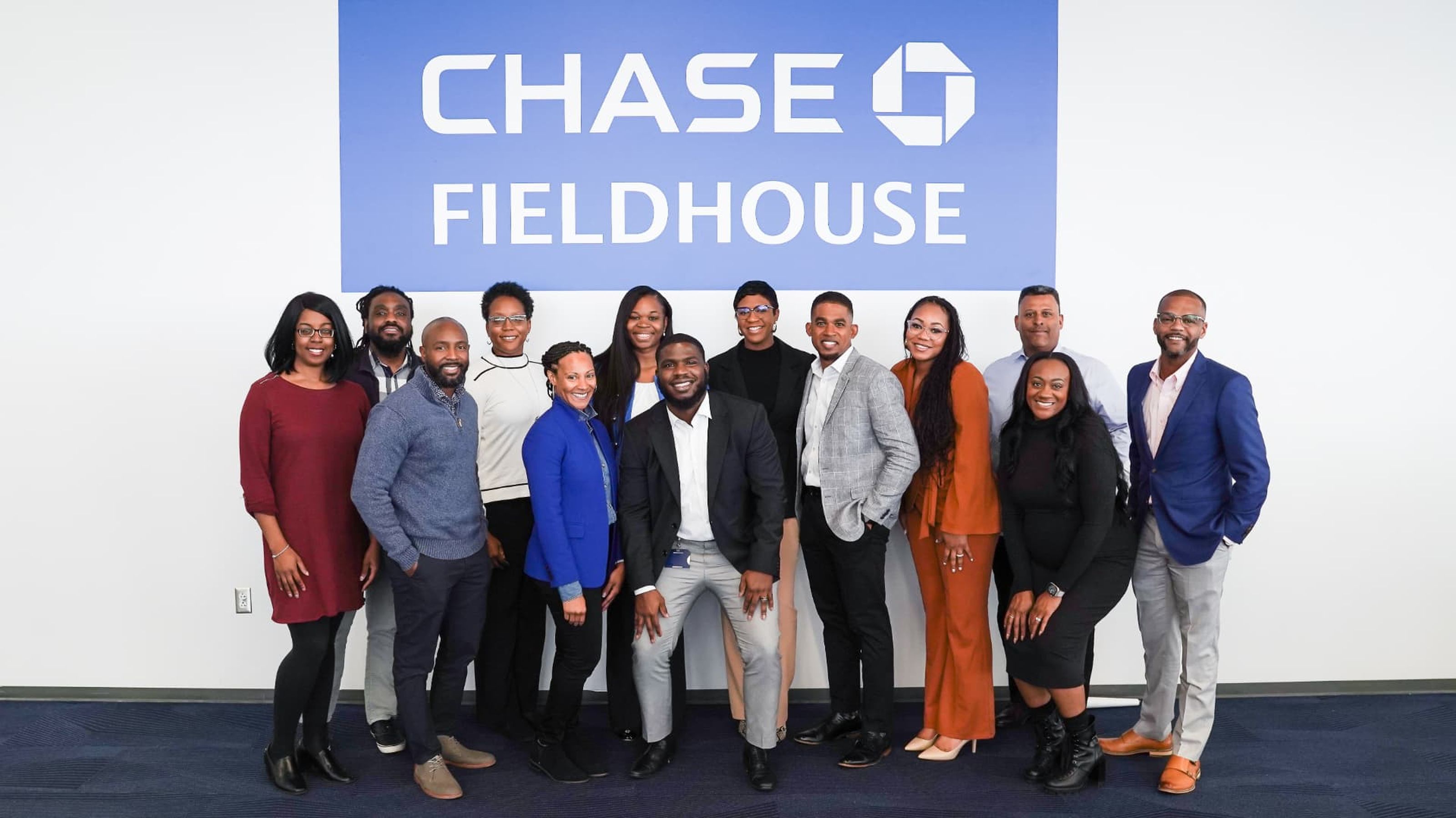 Group portrait beneath a branded wall sign